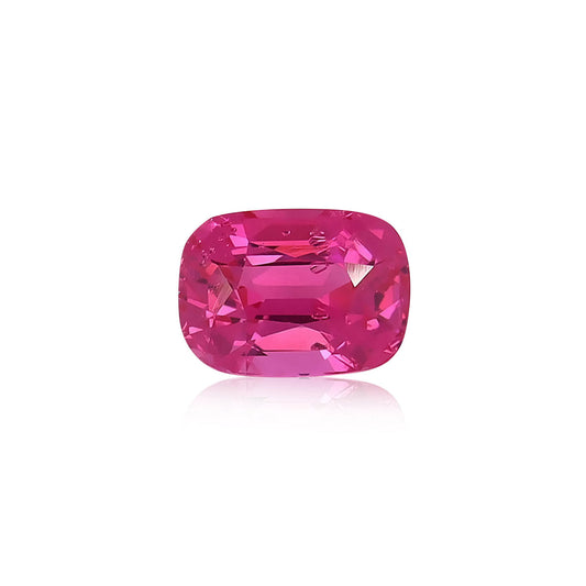 Une pierre précieuse Spinelle Mahenge taille coussin vibrante de Nascendi Paris d'un poids de 2,67 ct reflète la lumière, mettant en valeur sa couleur rose intense sur un fond blanc uni.