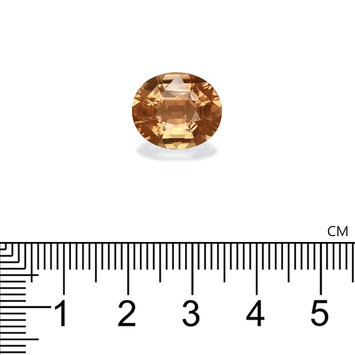 Une tourmaline jaune taille ovale de 6,68 ct de Bonnot Paris est posée au-dessus d'une règle, ses facettes complexes réfléchissant la lumière pour révéler sa clarté et sa riche teinte. La règle indique que la pierre mesure environ 1 cm de large.