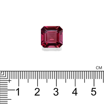 Une petite Tourmaline Rose rectangulaire rouge foncé · 6,58 ct de Bonnot Paris est placée sur un fond blanc, avec une règle centimétrique indiquant que sa largeur est d'un peu plus de 0,5 cm.