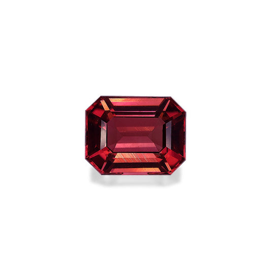Une Tourmaline Rose taille émeraude de 6,25 carats de Bonnot Paris, aux teintes rouges vibrantes et aux multiples facettes reflétant la lumière pour des nuances et une brillance variées, sur un fond blanc uni.