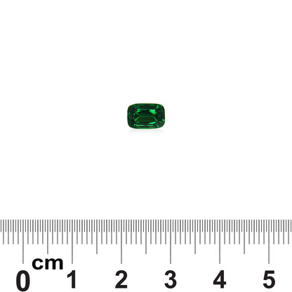 Une petite pierre précieuse rectangulaire de grenat tsavorite de Bonnot Paris est posée sur une surface blanche au-dessus d'une règle graduée en centimètres. La pierre verte mesure environ 0,7 cm de large.