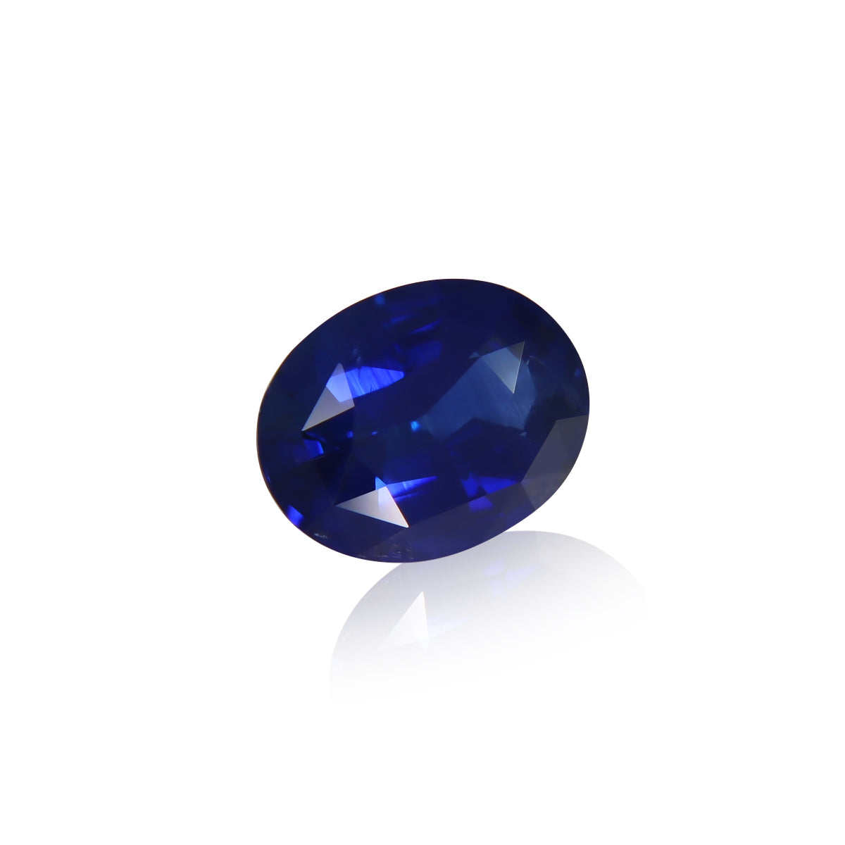 Le Saphir Bleu · 4,05 ct de Bonnot Paris est une pierre précieuse saphir bleu profond de forme ovale avec une surface facettée qui scintille lorsqu'elle reflète la lumière sur un fond blanc uni, soulignant sa couleur riche et sa clarté.