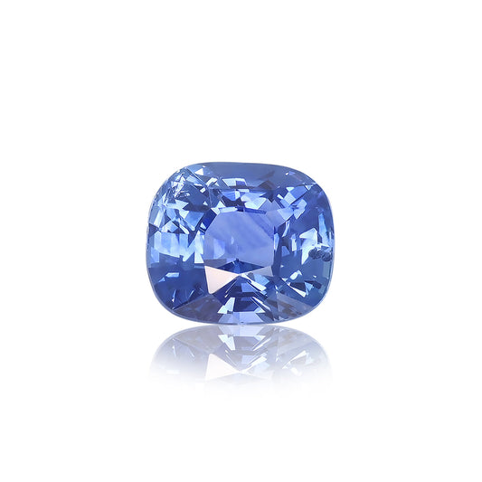 Le Saphir Bleu · 2,02 ct de Bonnot Paris, un saphir bleu taille coussin, reflète la lumière à travers ses facettes et scintille brillamment sur un fond blanc uni, soulignant sa teinte vibrante et sa clarté.
