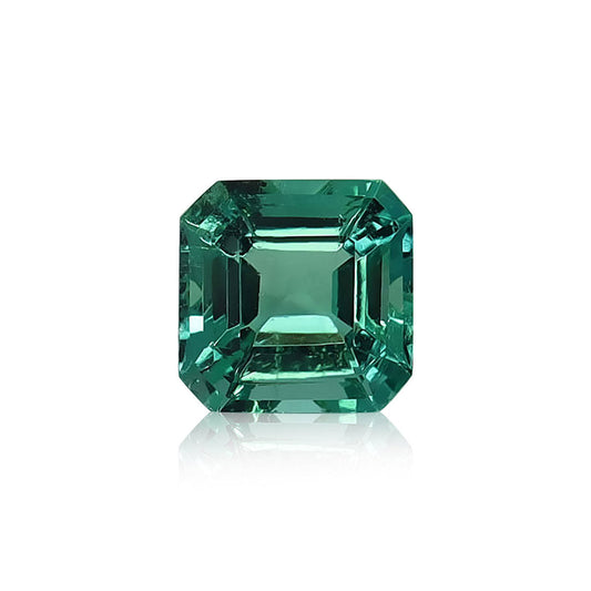 L'Émeraude de Zambie, une pierre précieuse de 1,57 carat de Bonnot Paris, est taillée en carré avec des bords biseautés et reflète magnifiquement la lumière sur un fond blanc.
