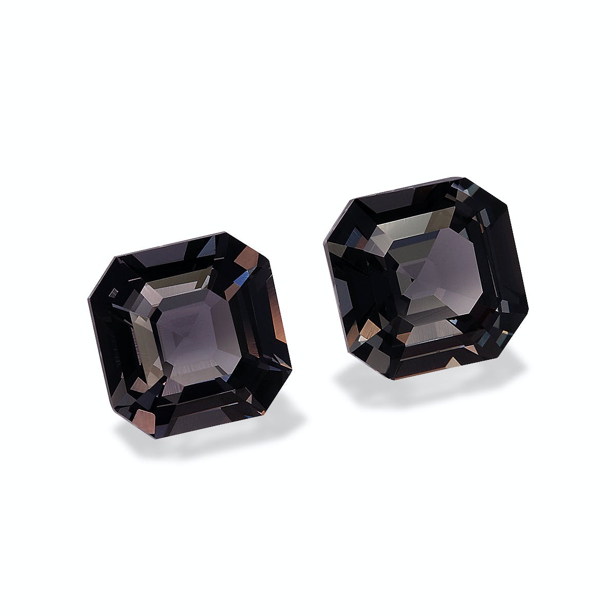 Deux spinelles octogonales, probablement gris foncé, se détachent sur un fond clair et épuré. Chaque pierre précieuse de 4,52 carats, signée Bonnot Paris, présente des surfaces réfléchissantes et des facettes complexes.