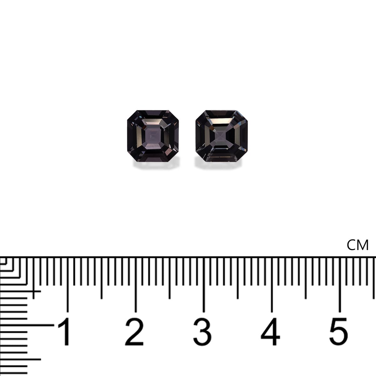 Deux pierres précieuses noires octogonales de Bonnot Paris, plus précisément le Spinelle Gris · 4,52 ct, sont placées à côté d'une règle centimétrique pour l'échelle.