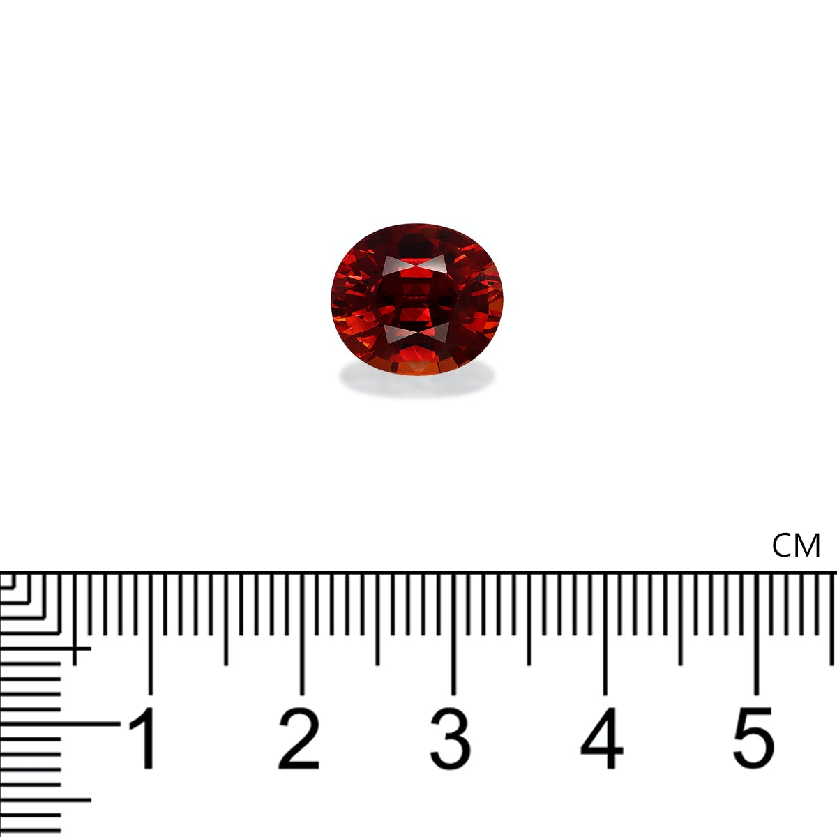 Un grenat spessartite (6,15 ct) de Bonnot Paris, de taille ovale et d'une teinte riche et profonde, est présenté au-dessus d'une règle métrique indiquant une largeur d'un peu plus d'1 cm. Sa surface facettée reflète magnifiquement la lumière.