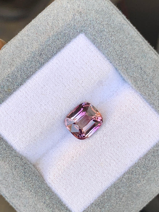 Le Saphir Bicolore • 2,65 carats de Bonnot Paris est élégamment présenté sur un fond blanc matelassé dans un coffret gris. Sa teinte riche attire le regard grâce à sa parfaite mise en valeur.