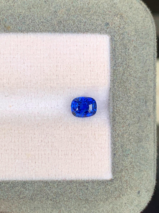 Sur un fond de tissu léger encadré d'une bordure grise texturée, le Saphir Bleu • 1,03ct de [NOUVEAU] Bonnot Paris met en valeur sa taille ovale vive en bleu royal, provenant des célèbres mines du Sri Lanka, incarnant l'essence des véritables pierres précieuses.
