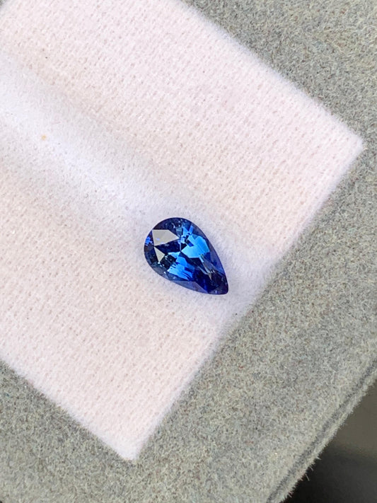 Le produit "Saphir Bleu • 1,12ct" de [NOUVEAU] Bonnot Paris présente un saphir naturel de Ceylan en forme de poire reposant sur un tissu léger, mettant en valeur ses teintes bleues vives et son éclat radieux.