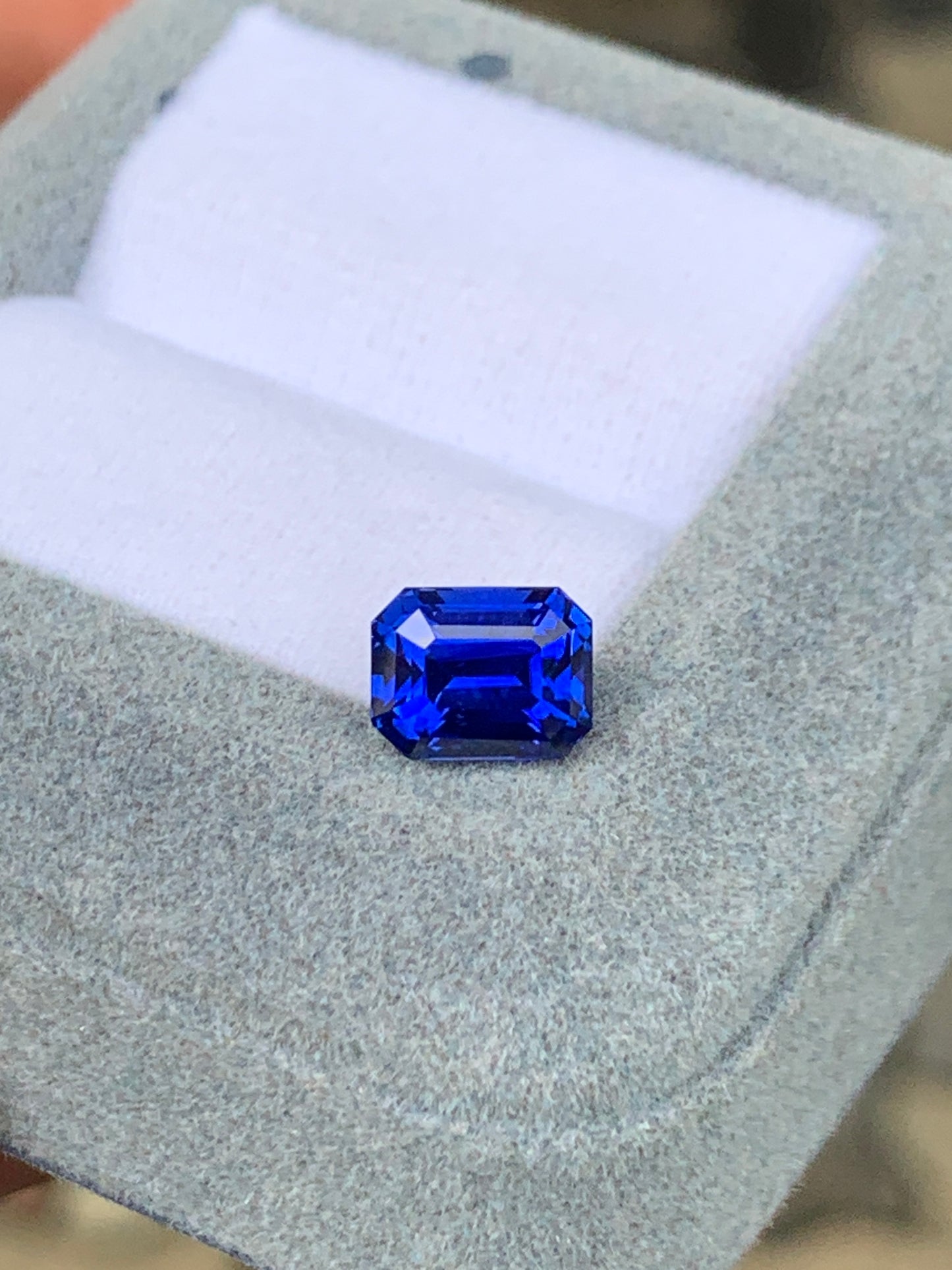 Le Saphir Bleu • 2,56ct de [NOUVEAU] Bonnot Paris brille avec élégance dans un écrin ouvert en velours gris, contrastant joliment avec la doublure intérieure blanche.