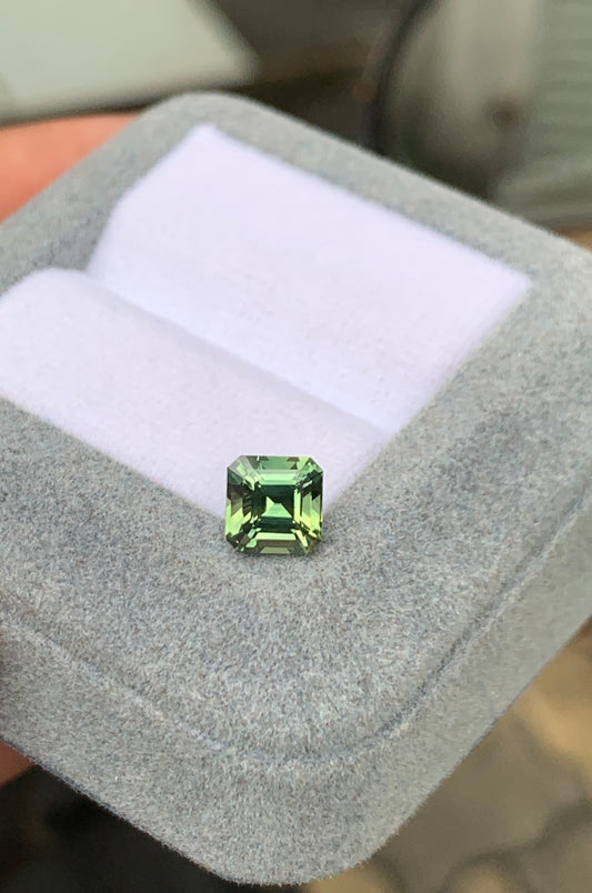 La pierre précieuse Saphir Vert · 1,78ct, réalisée par [NOUVEAU] Bonnot Paris, repose élégamment sur un écrin en velours gris clair.