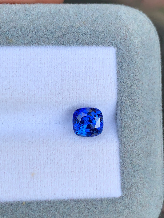 Un Saphir bleu vibrant de 2,20 ct de Bonnot Paris est élégamment présenté sur un coussin blanc à l'intérieur d'un écrin à bijoux gris.