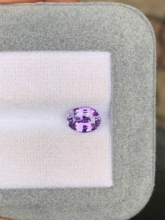 Présenté sur un coussin blanc à l'intérieur d'un cadre gris, le saphir violet ovale de 1,53 ct de Bonnot Paris en provenance du Sri Lanka présente une taille facettée qui capture magnifiquement la lumière, ce qui en fait un trésor vibrant parmi les pierres précieuses.
