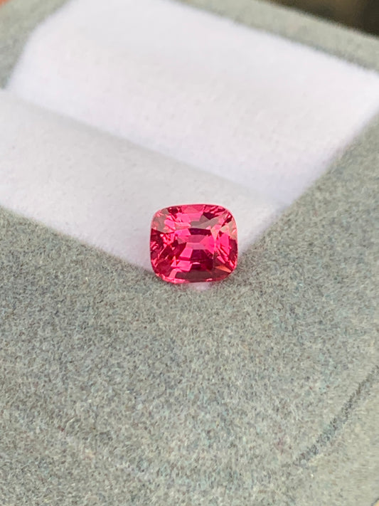 Le Spinelle Mahenge • 1,52ct de Bonnot Paris, taille coussin unique, repose élégamment sur un écrin en velours gris à l'intérieur blanc.