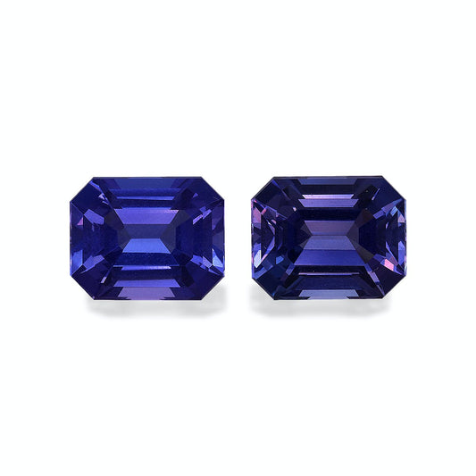 Deux tanzanites Bonnot Paris rectangulaires et facettées (6,9 carats), aux nuances violettes profondes, sont mises en valeur sur un fond uni. Leurs surfaces réfléchissantes mettent en valeur des coupes complexes et des couleurs éclatantes.
