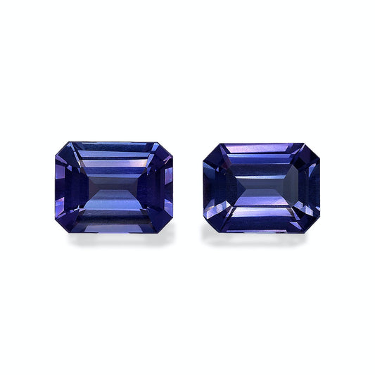 Deux pierres précieuses Tanzanite rectangulaires taille émeraude, de 5,82 ct chacune par Bonnot Paris, affichent une couleur bleu profond avec des facettes qui reflètent la lumière pour mettre en valeur des nuances de bleu et des touches de violet sur un fond clair.