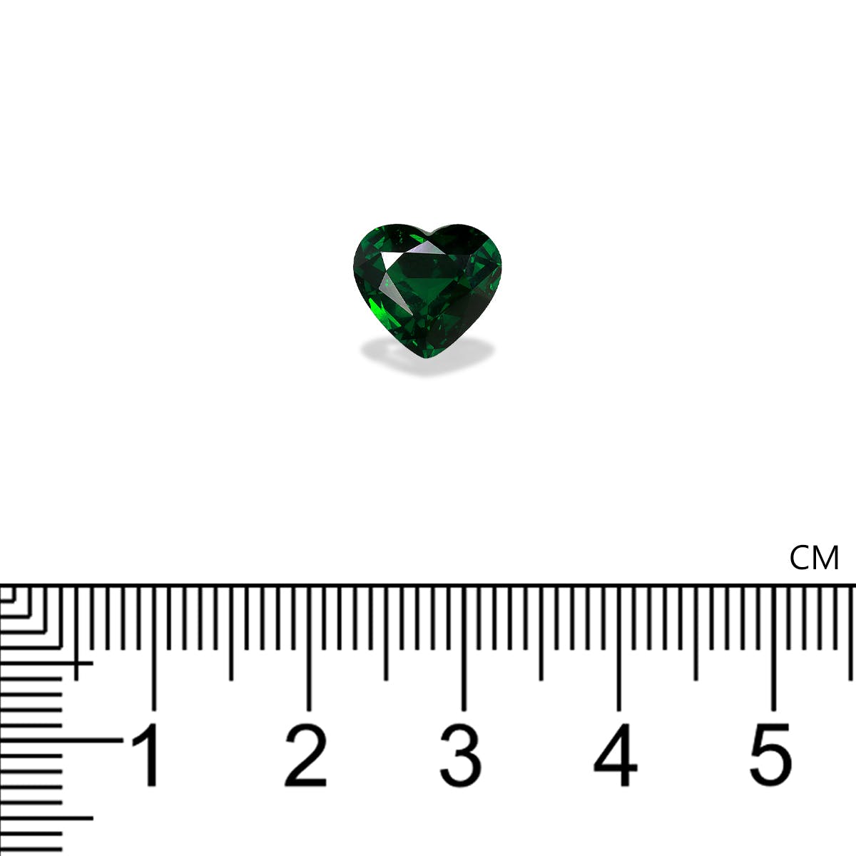 La pierre précieuse Grenat Tsavorite en forme de cœur de Bonnot Paris pèse 2,18 carats et est présentée sur un fond blanc à côté d'une règle avec des graduations en centimètres, soulignant sa taille inférieure à 1 centimètre.