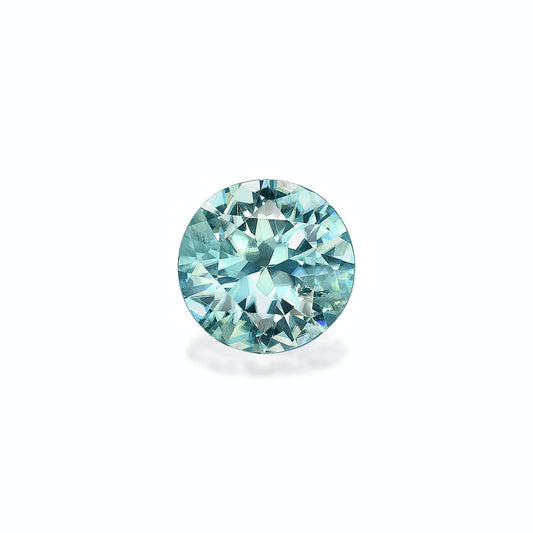Le Zircon Bleu Bonnot Paris, une pierre ronde de 3,25 carats d'une teinte bleu clair, se détache sur un fond blanc uni. Ses facettes complexes reflètent la lumière, créant un effet scintillant.