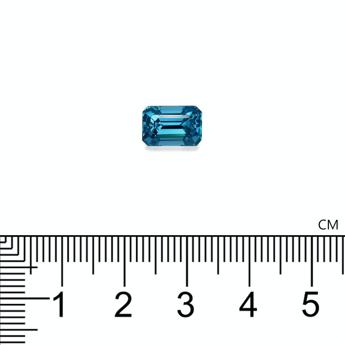 Un Zircon Bleu de 4,29 carats de Bonnot Paris, de taille émeraude et de forme rectangulaire, est présenté à côté d'une règle graduée en centimètres sur un fond blanc uni, mesurant un peu plus de 1 cm.