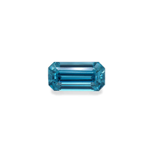 Une pierre précieuse Zircon Bleu rectangulaire allongée facettée de 4,44 ct avec des bords biseautés par Bonnot Paris, reflétant la lumière sur un fond blanc uni.