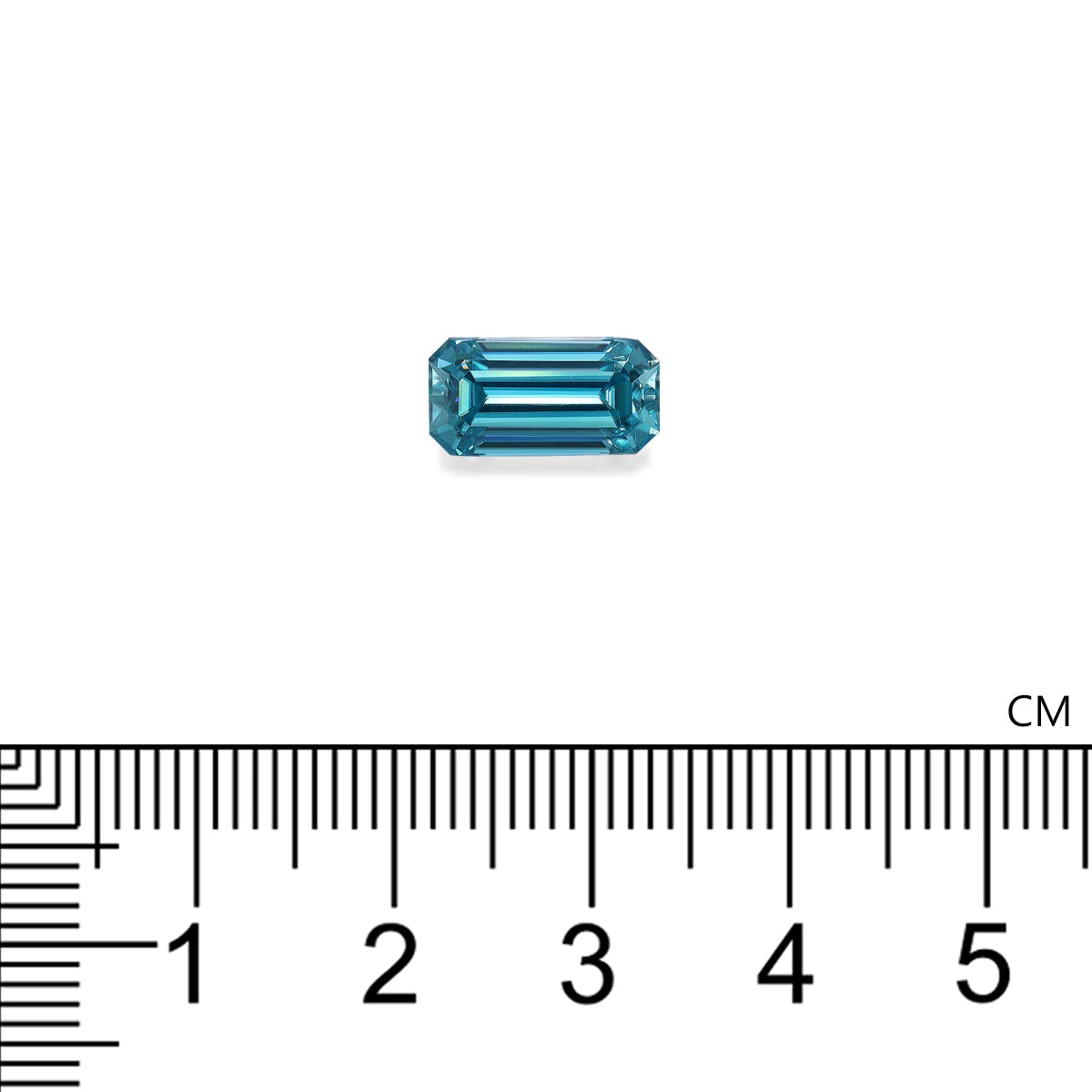 Une petite pierre précieuse rectangulaire Zircon Bleu · 4,75 ct de Bonnot Paris se trouve au-dessus d'une règle marquée en centimètres, mettant en valeur son design en gradins et sa transparence.