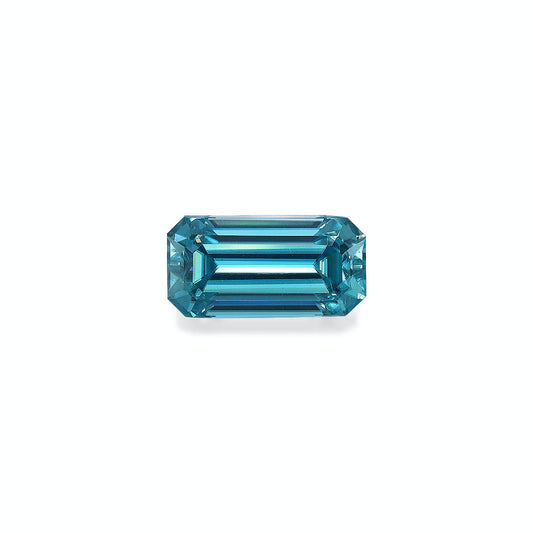 Le Zircon Bleu · 4,75 ct de Bonnot Paris est une pierre précieuse bleue facettée, taille émeraude, de forme rectangulaire allongée et aux coins biseautés, présentée sur un fond blanc uni pour plus de clarté et de brillance réfléchissante.