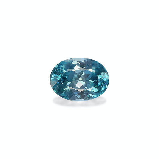 Le Zircon Bleu, une pierre précieuse de 6,12 carats signée Bonnot Paris, présente une forme ovale facettée et repose sur une surface gris clair. Sa teinte bleue scintillante présente différentes nuances avec des touches de cyan et de bleu sarcelle, tandis que ses facettes reflètent la lumière pour créer un effet scintillant.